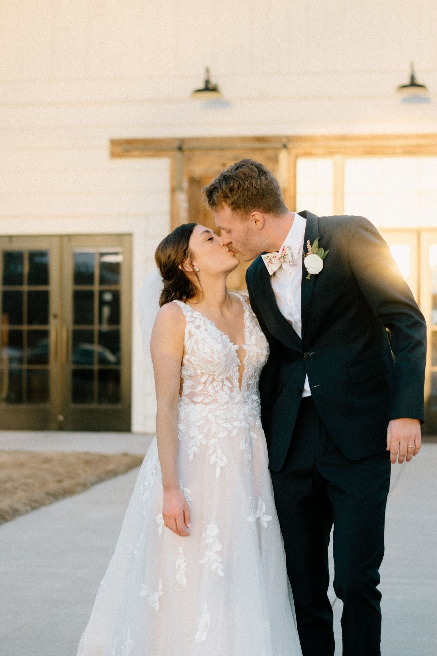 Dreamy wedding moment captured in front of a light-filled modern building interior.