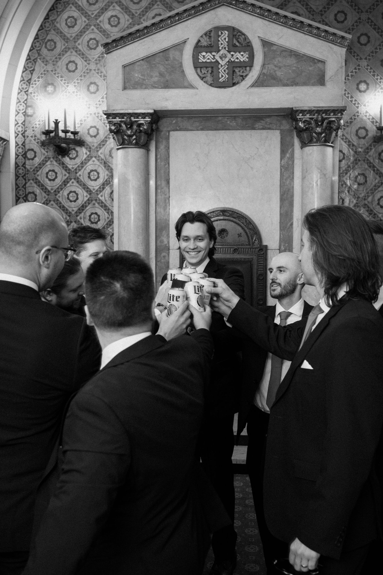 Black and white photo sequence showing groomsmen in formal suits interacting at a wedding celebration.