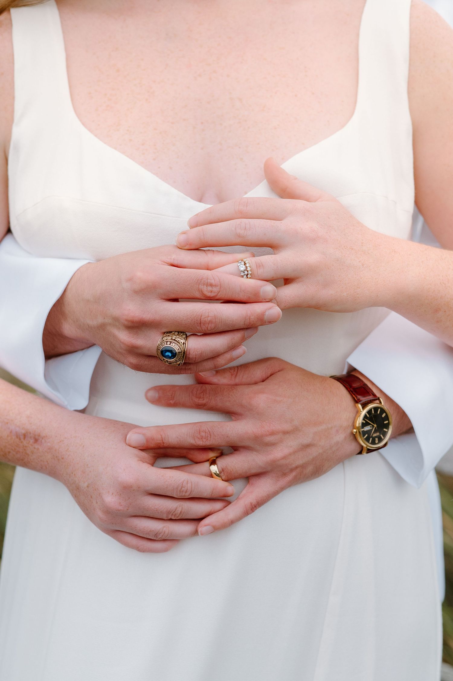 Close-up shots of hands wearing elegant rings against a white dress background.