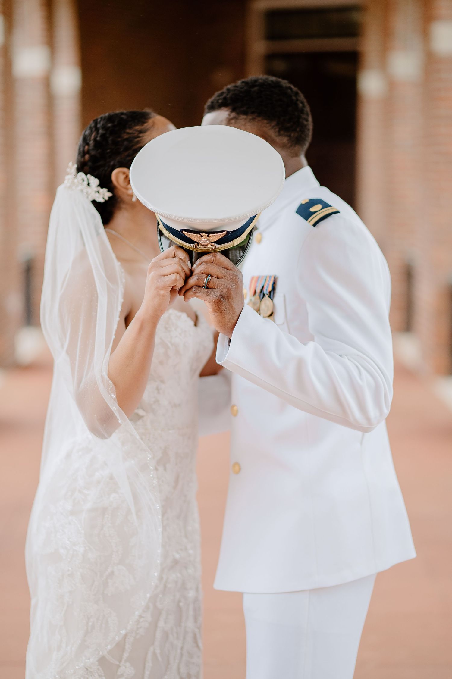 Two people in elegant white wedding attire share an intimate moment together.