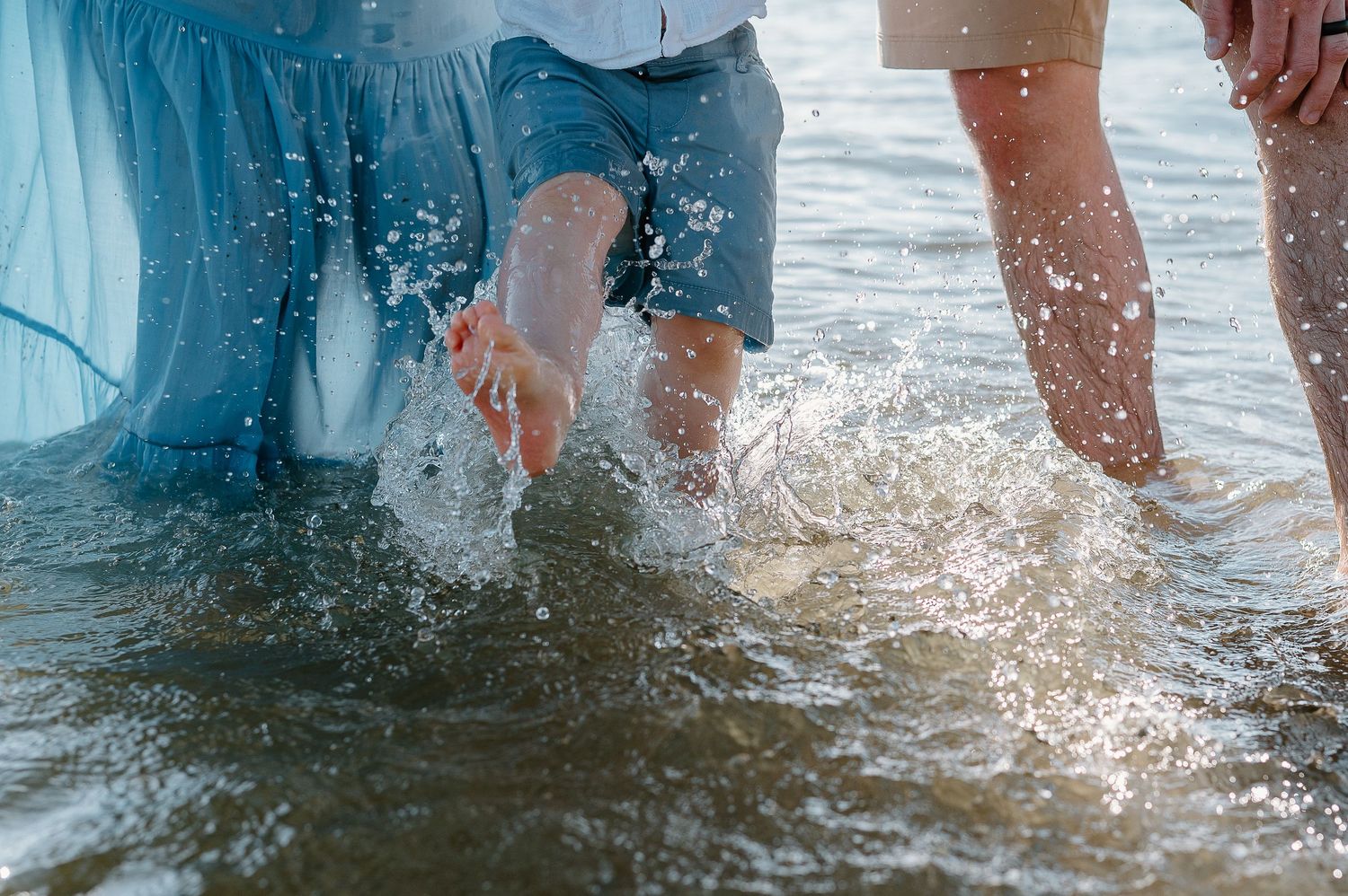Splashing water at the beach shore creates sparkling reflections in the sunlight.