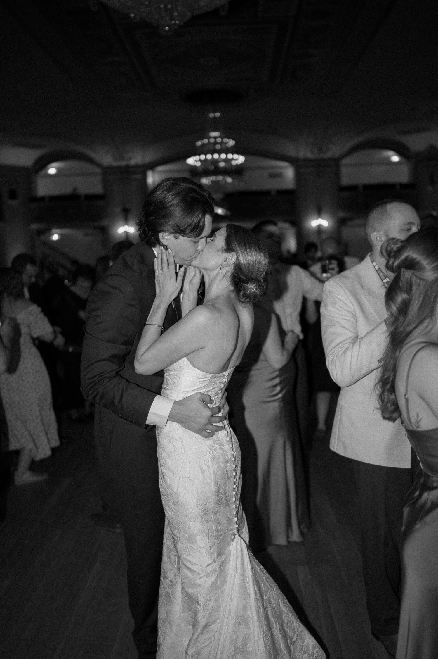 Black and white photo series showing couples slow dancing together at a wedding reception in a dimly lit ballroom.