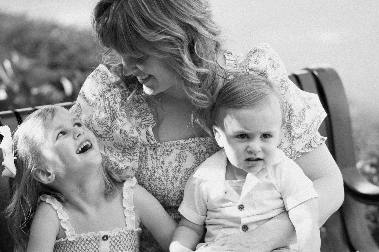 Baby holding hand and reaching up in a tender emotional moment during family photoshoot.