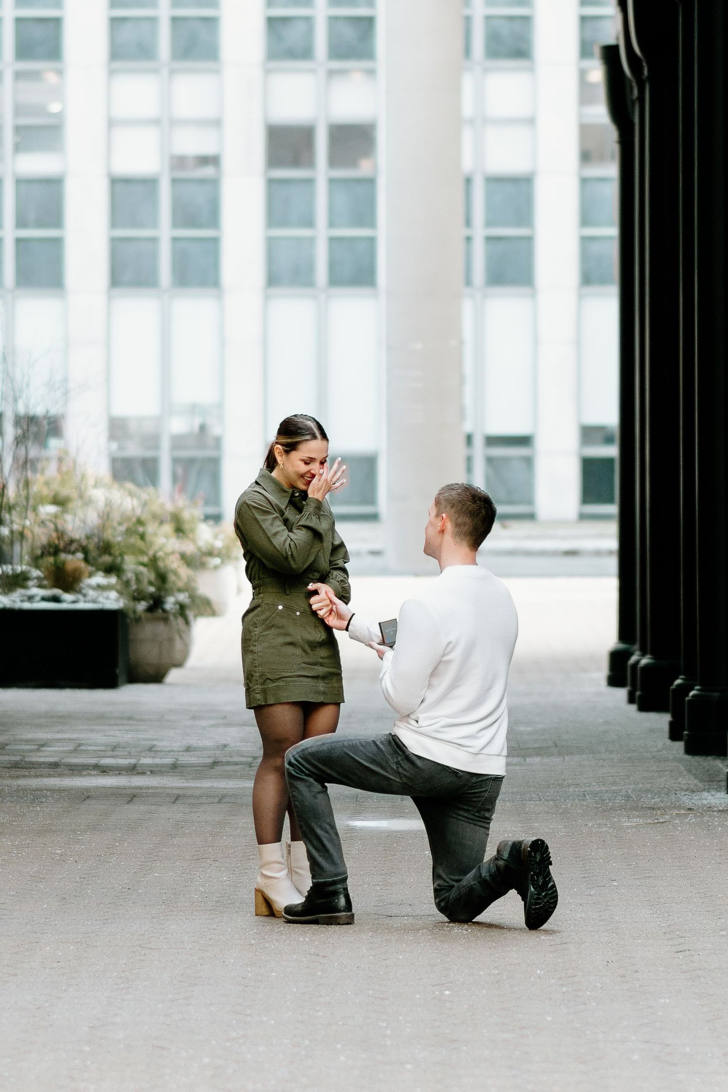 Marriage proposal scene with couple in outdoor courtyard surrounded by columns.