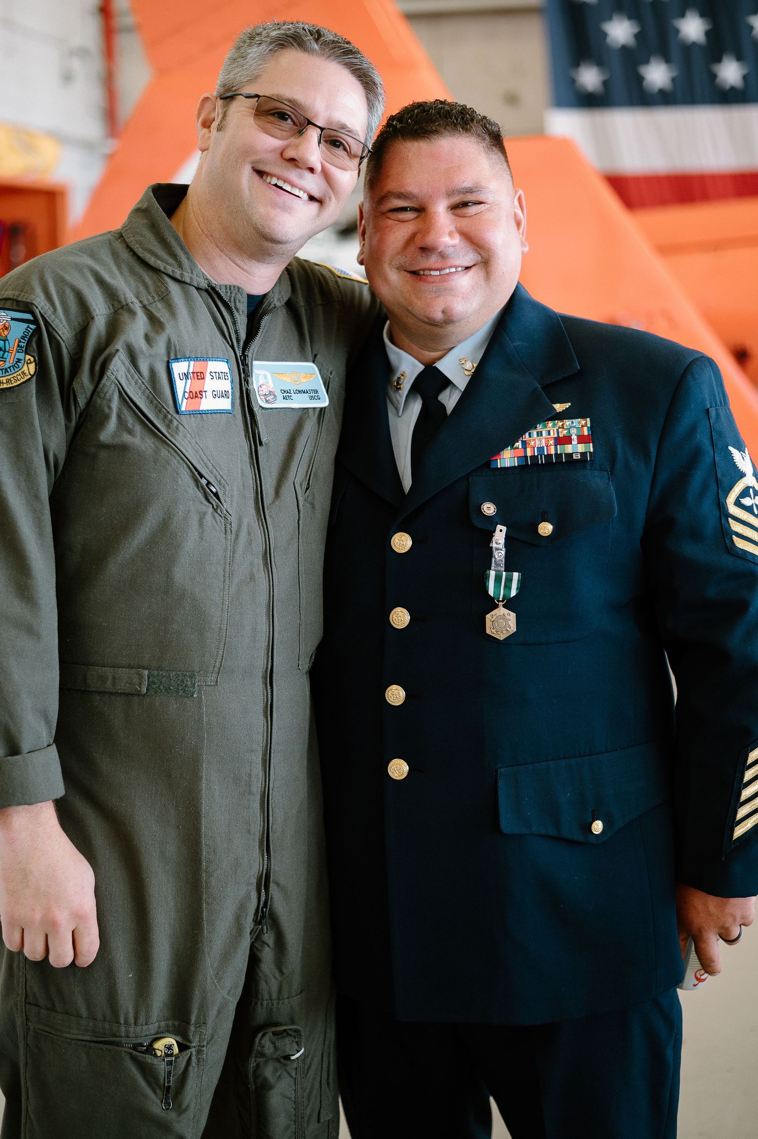 Military personnel in dress uniforms and flight suits pose together at an official event.