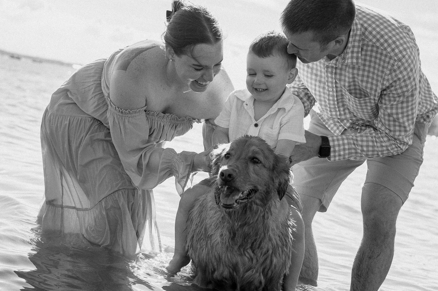 Joyful family moments shared at the beach's edge with water splashing.