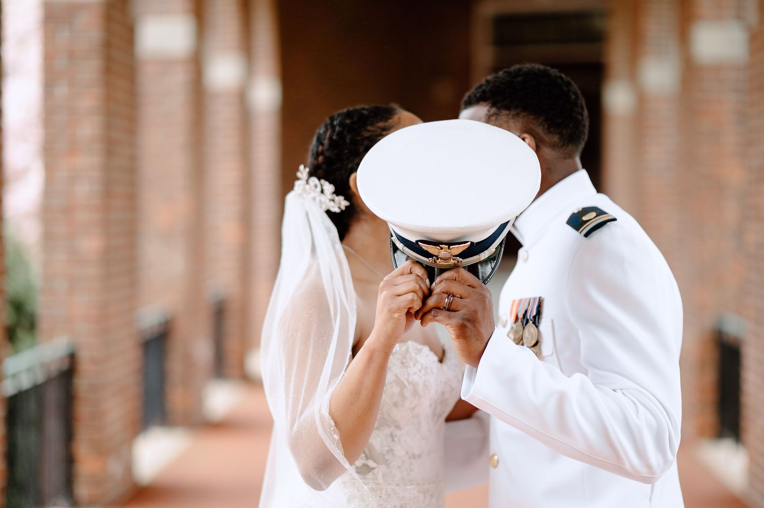 Two figures in white embrace during what appears to be a formal celebration or ceremony.