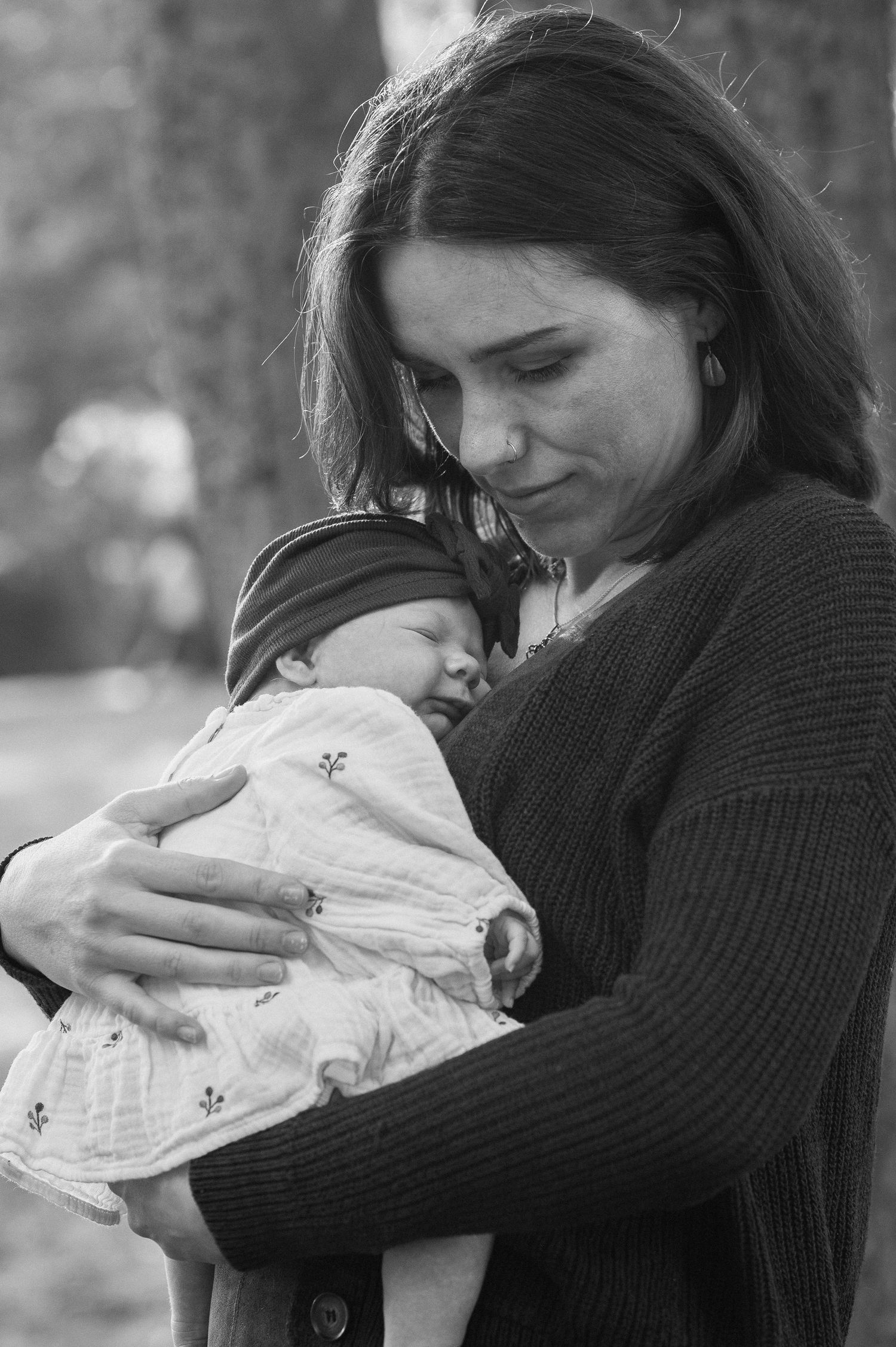 A tender black and white moment of comfort between parent and baby in warm knitwear.