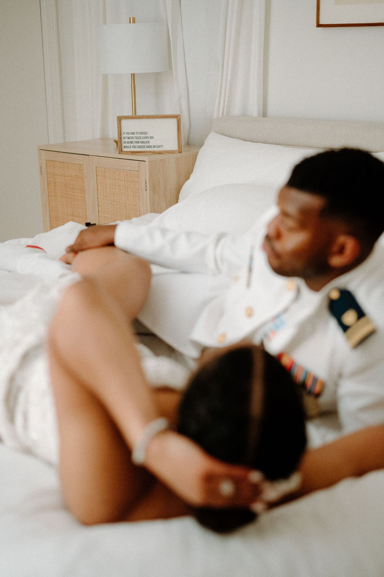 An intimate morning moment captured in soft light with white bedding.