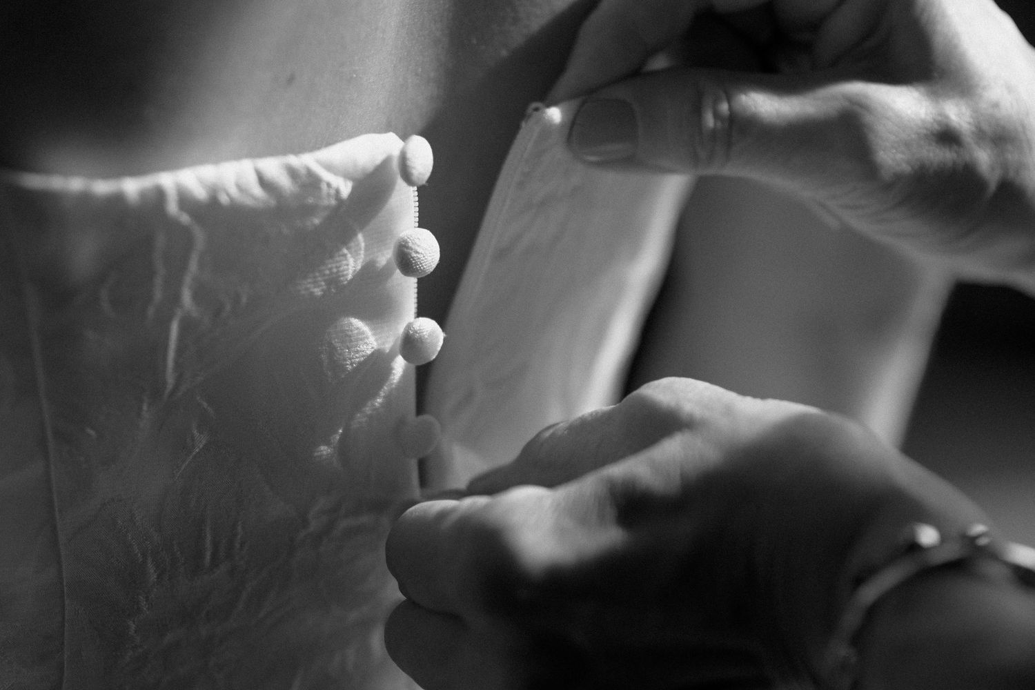Black and white photo series showing hands holding and lighting a cigarette in dramatic lighting.