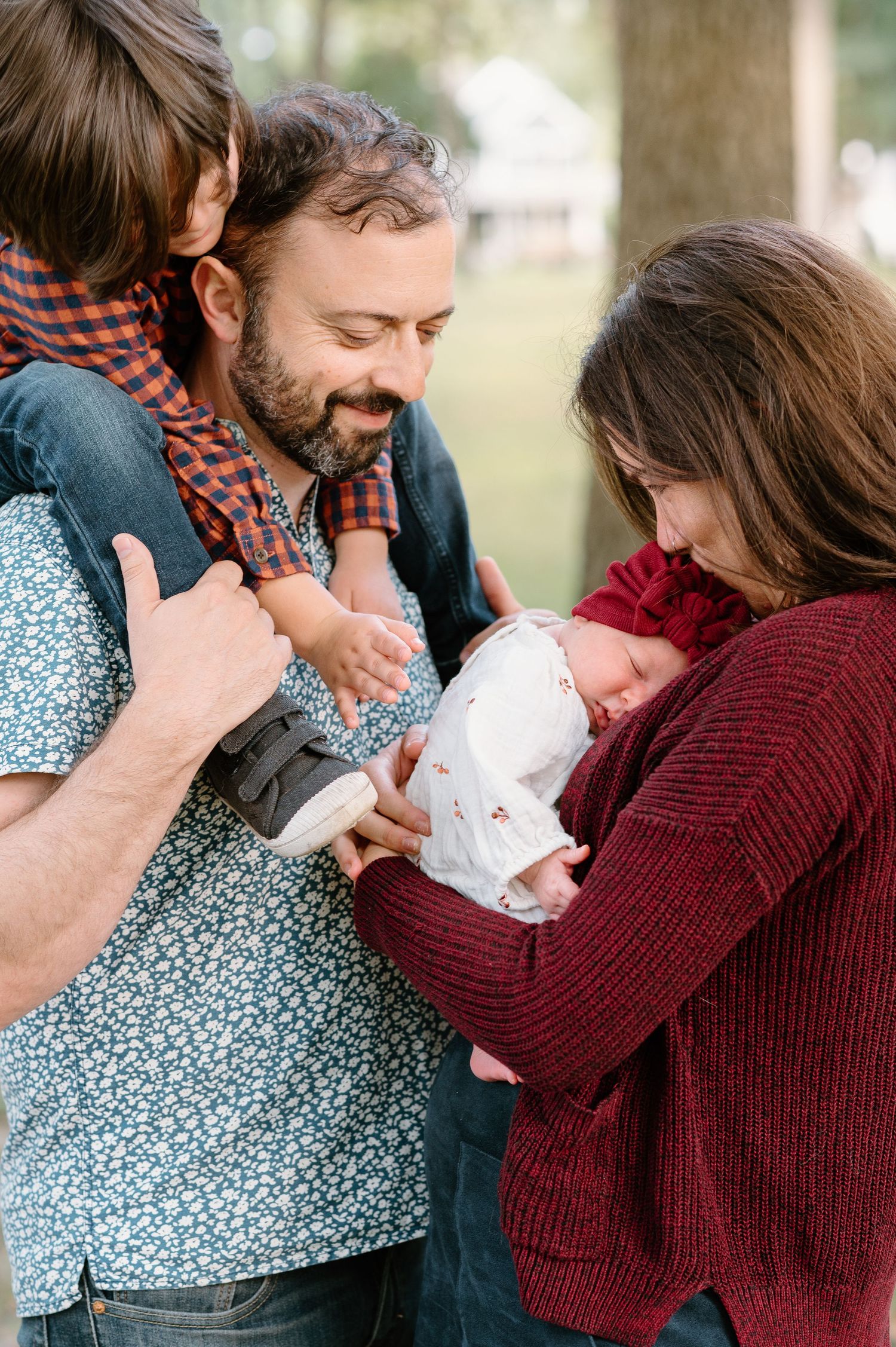 Intimate family moment as parents gather close around their newborn baby.