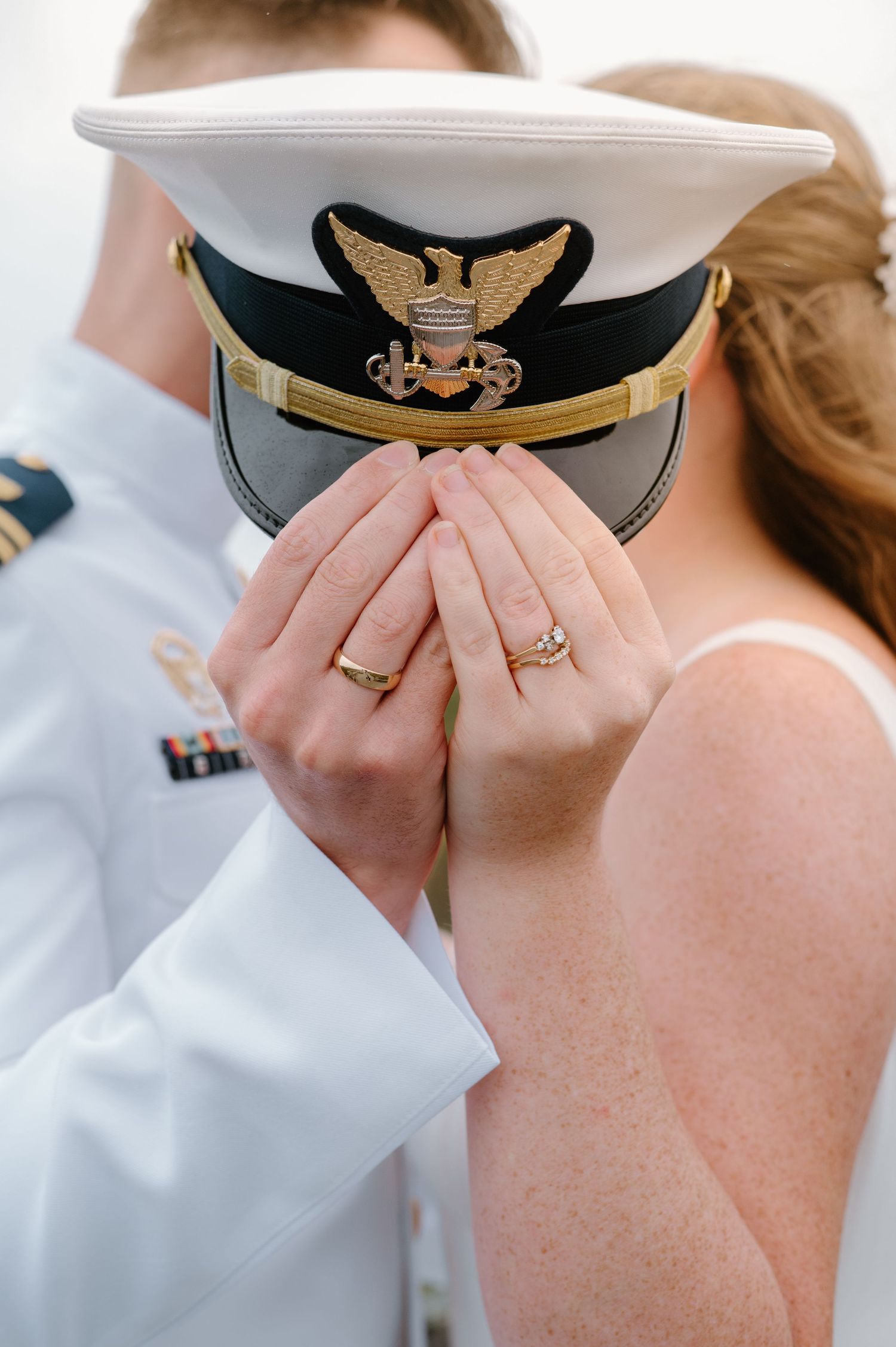 Detail shots of hands touching with a naval officer's hat visible in the background.