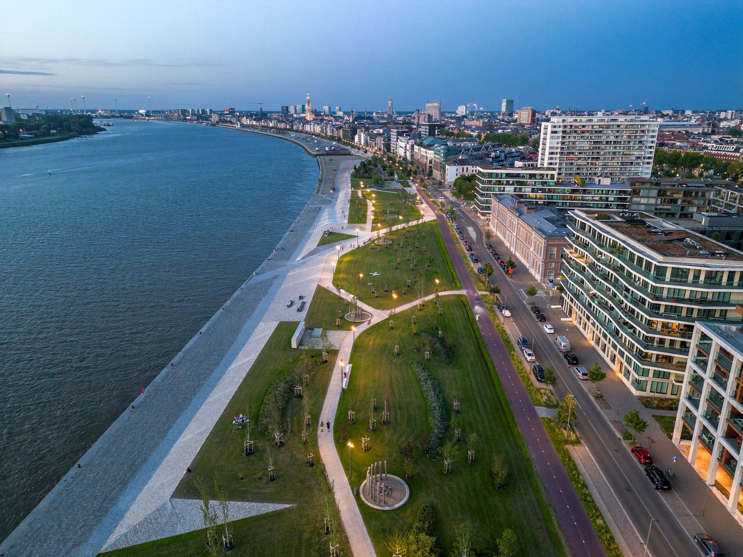 Luchtfoto van een schilderachtig rivierpark in Antwerpen bij schemering, gefotografeerd door Roger