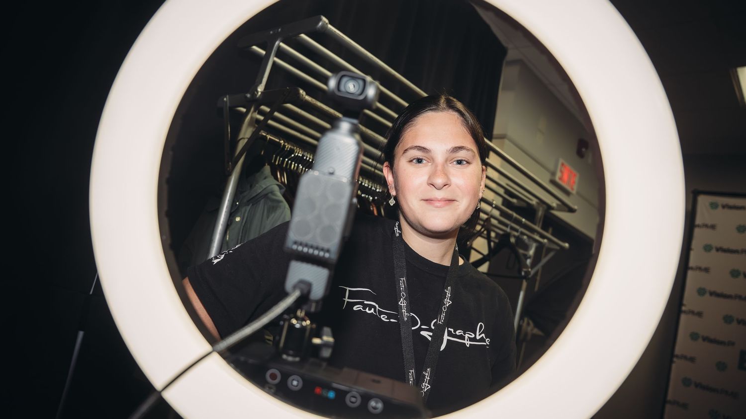 Ring light photography setup with camera equipment in dark studio setting.