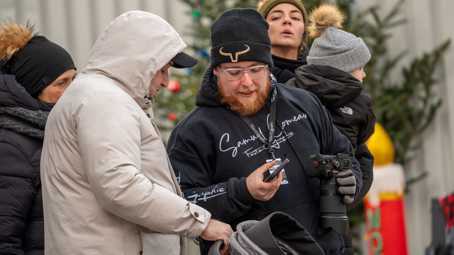 Suspect in a black beanie and mask is being apprehended by law enforcement officers during a police operation.