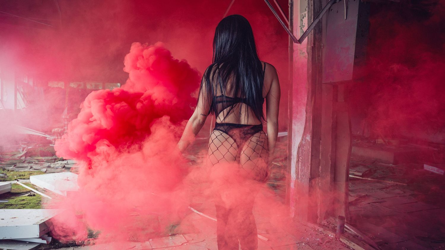 Red smoke fills the air at a soccer match as flares create an intense atmospheric effect during a sporting event.