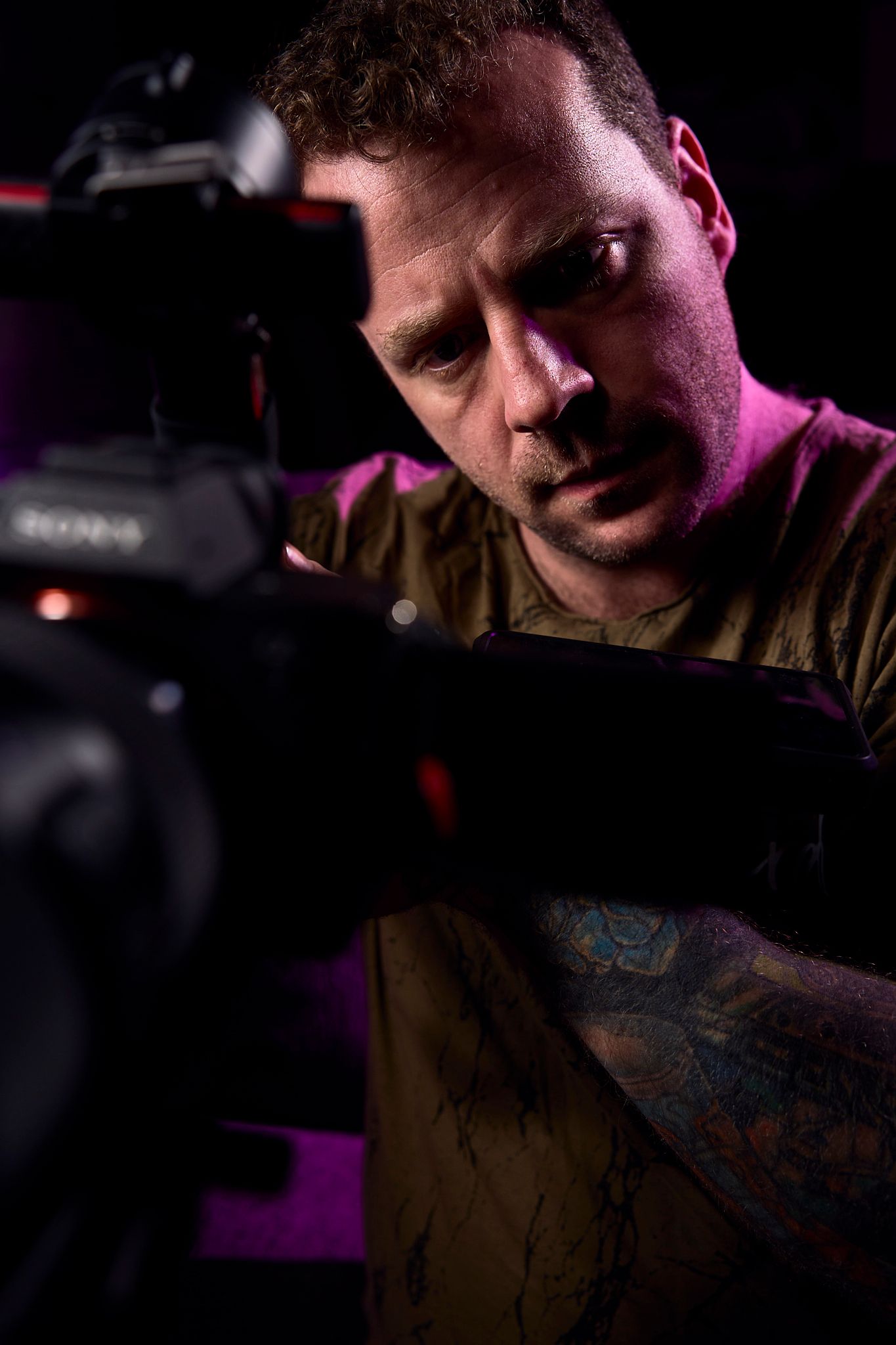 Dramatic low-light portrait with moody purple lighting and shadows.