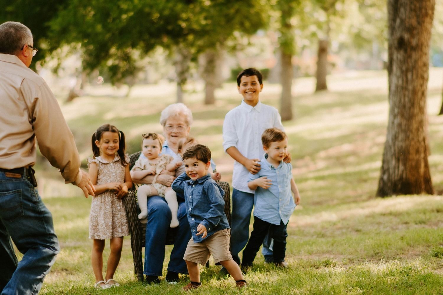 Children playing and running on a grassy hill while being photographed.