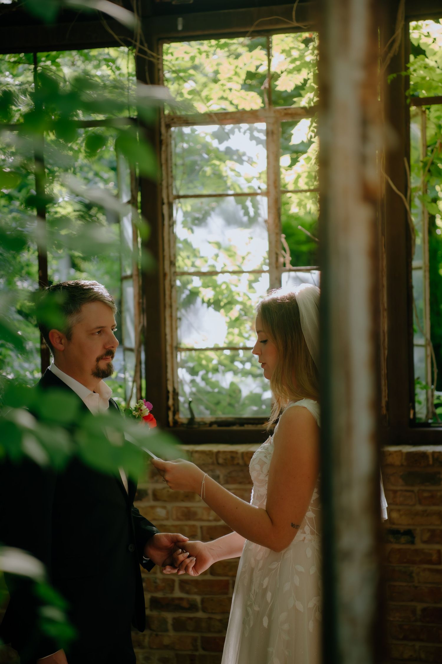Exchange of rings during an intimate greenhouse wedding ceremony.