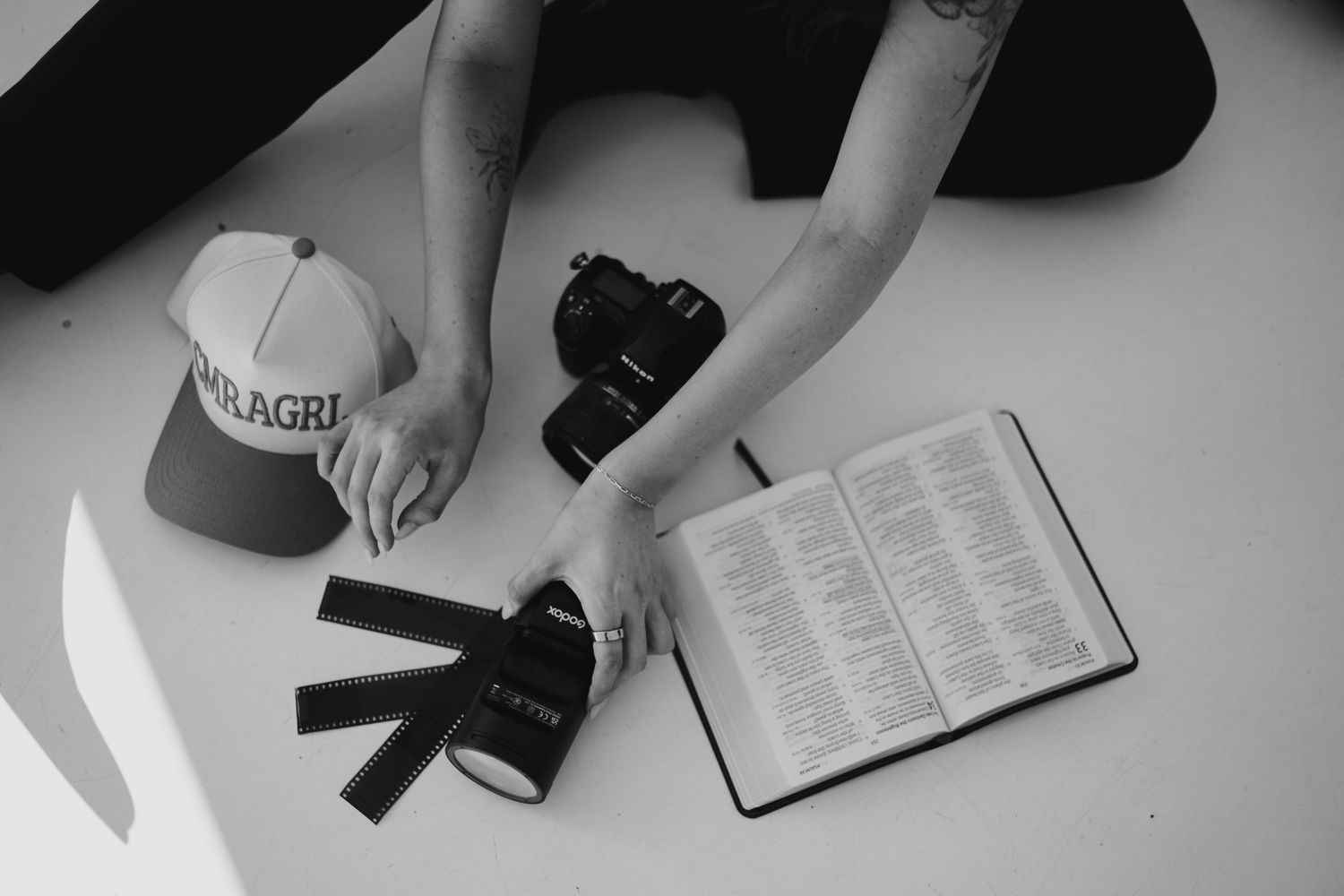 A black and white photo series showing hands reading and holding open books and journals in various positions.