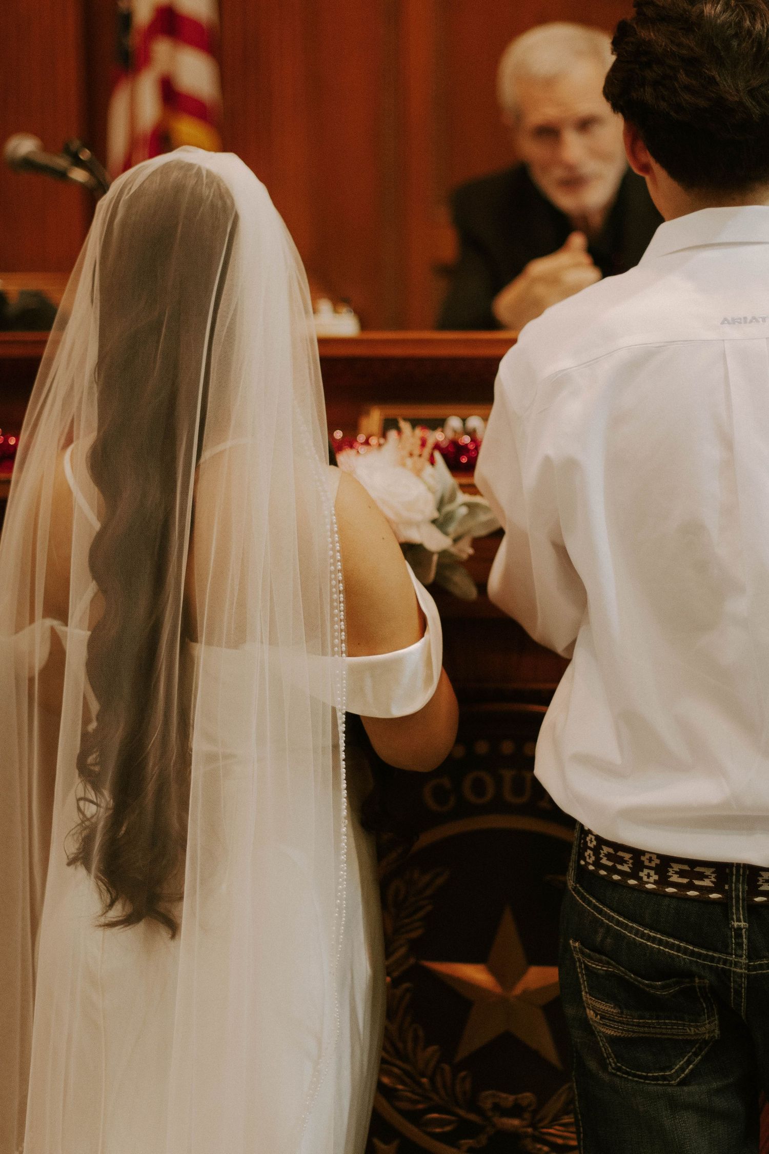Couple stands before a judge in a courthouse during their wedding ceremony.