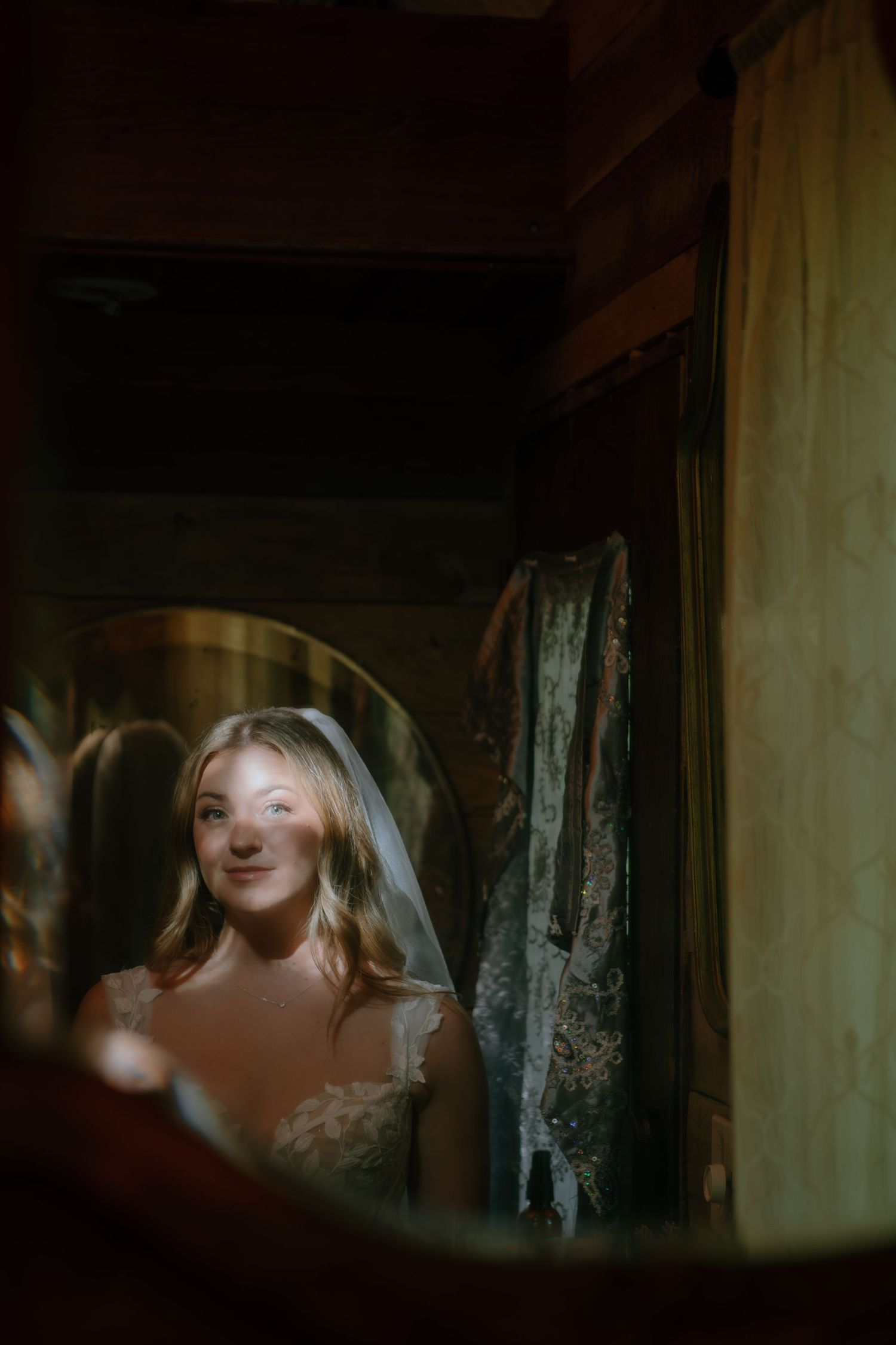 A soft, dreamy reflection captured in a vintage mirror showing a wedding veil and dress.