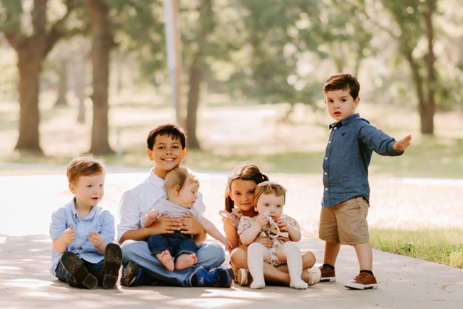 Candid moments captured of people laying and playing on grass during an outdoor photoshoot.