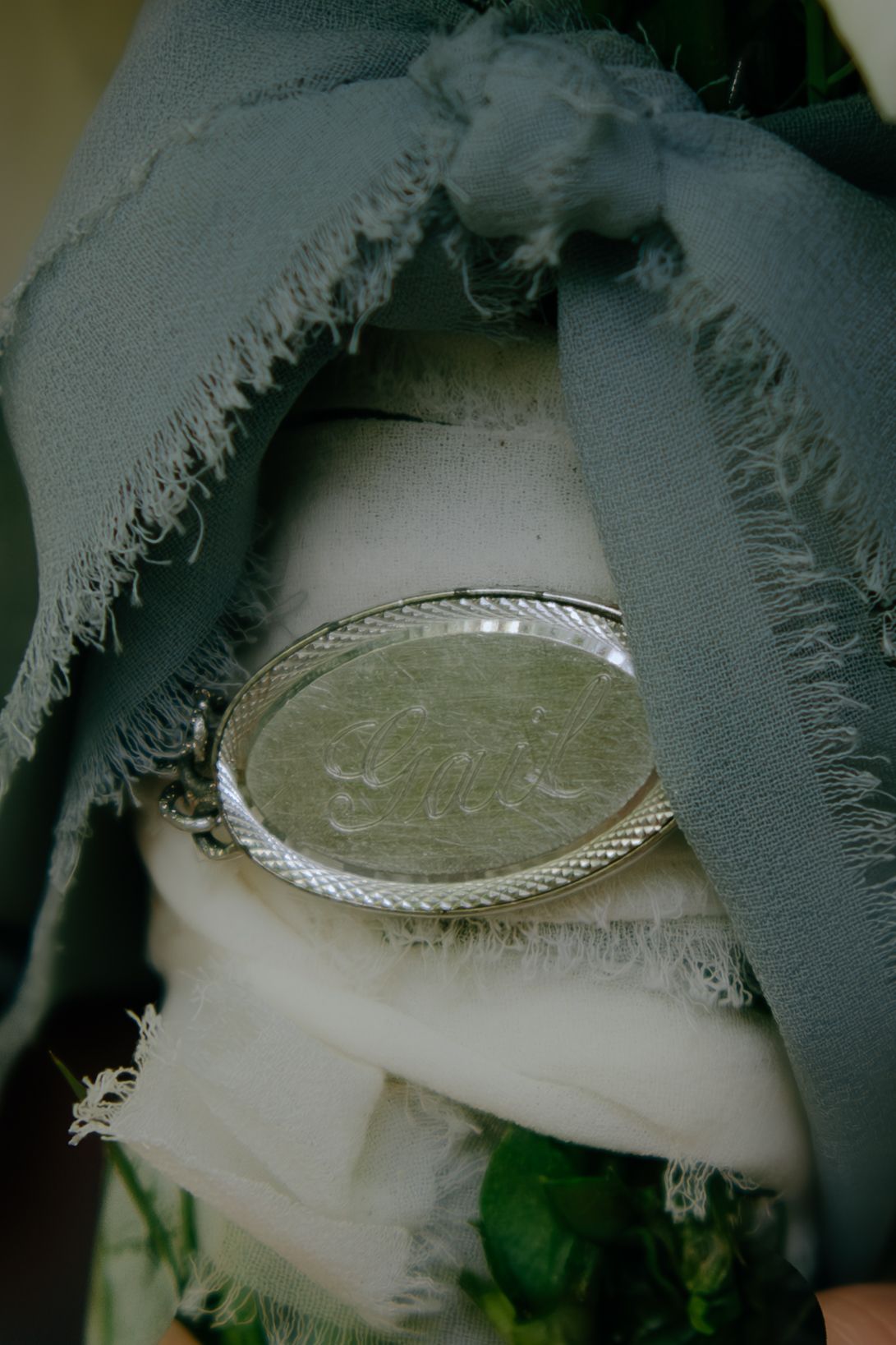 Decorative silver plate surrounded by grey fabric with frayed edges.