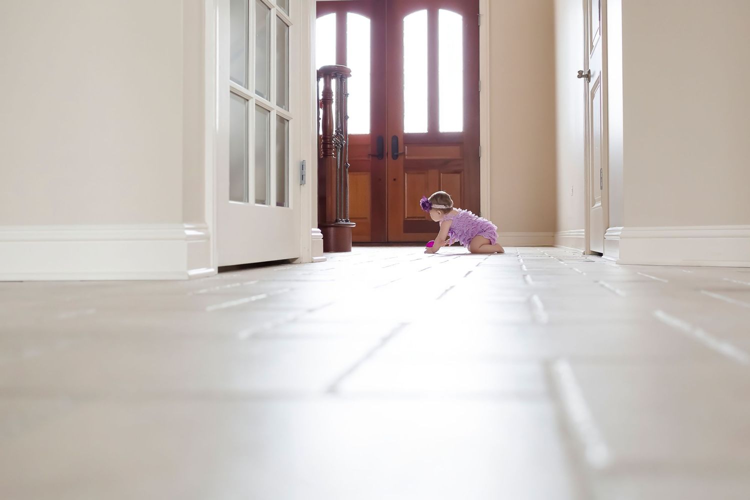 White hallway with natural light streaming through windows and doorways showing interior architectural details.