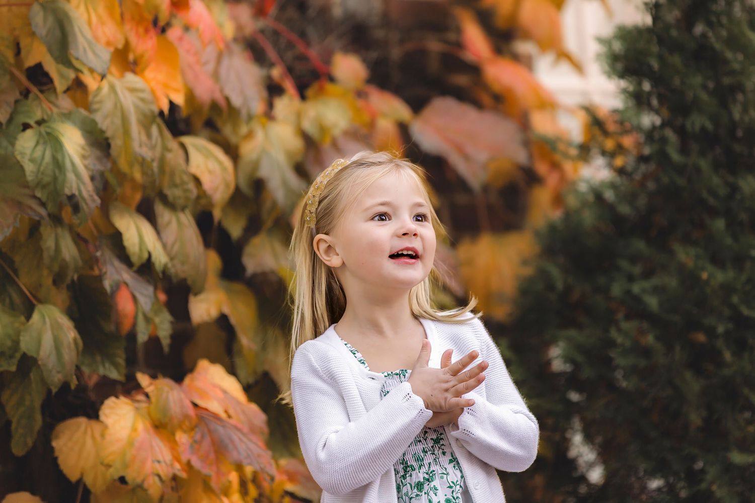 A joyful moment captured in an autumn setting with golden leaves falling from trees.
