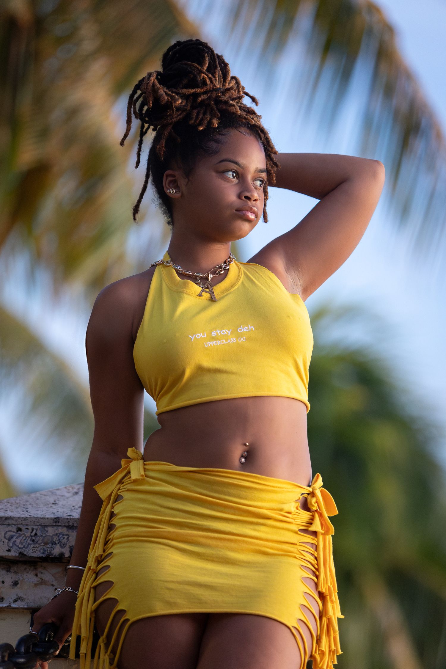 Yellow outfit against tropical palm tree background in bright sunlight.