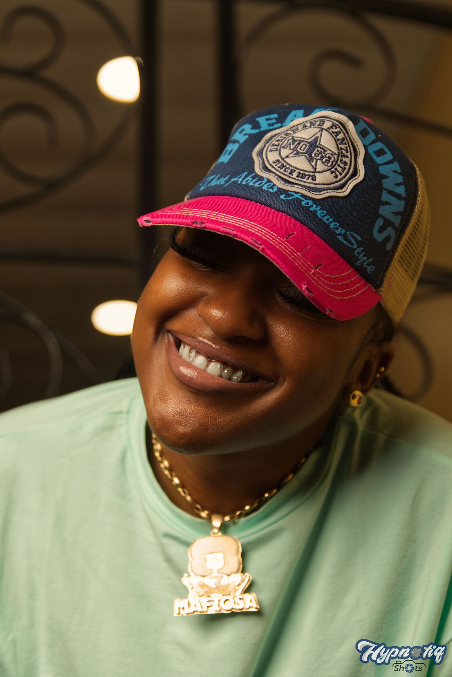 Series of casual portraits wearing baseball cap and mint green shirt with gold necklace.
