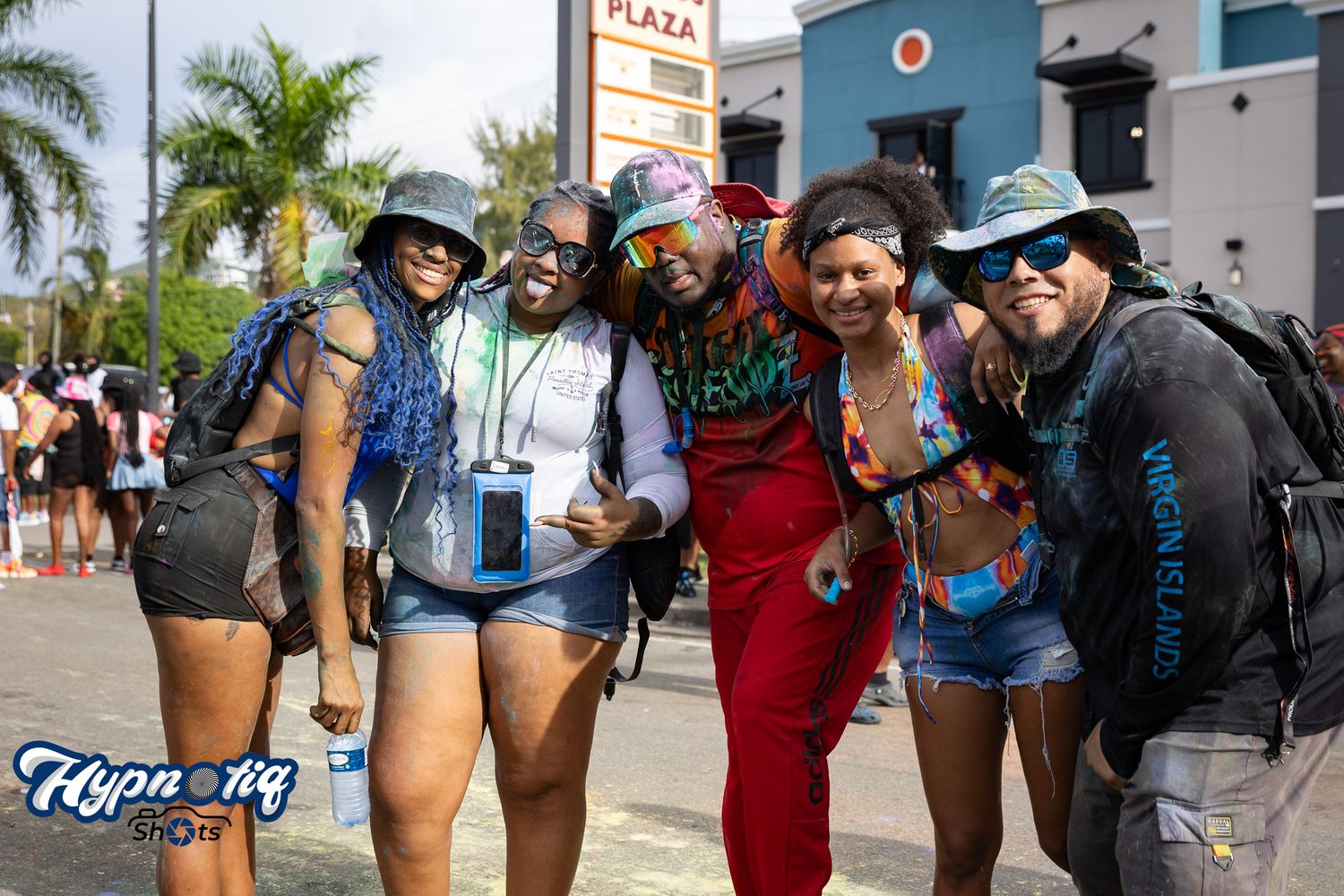 Group gathering outside tropical storefront with palm trees.