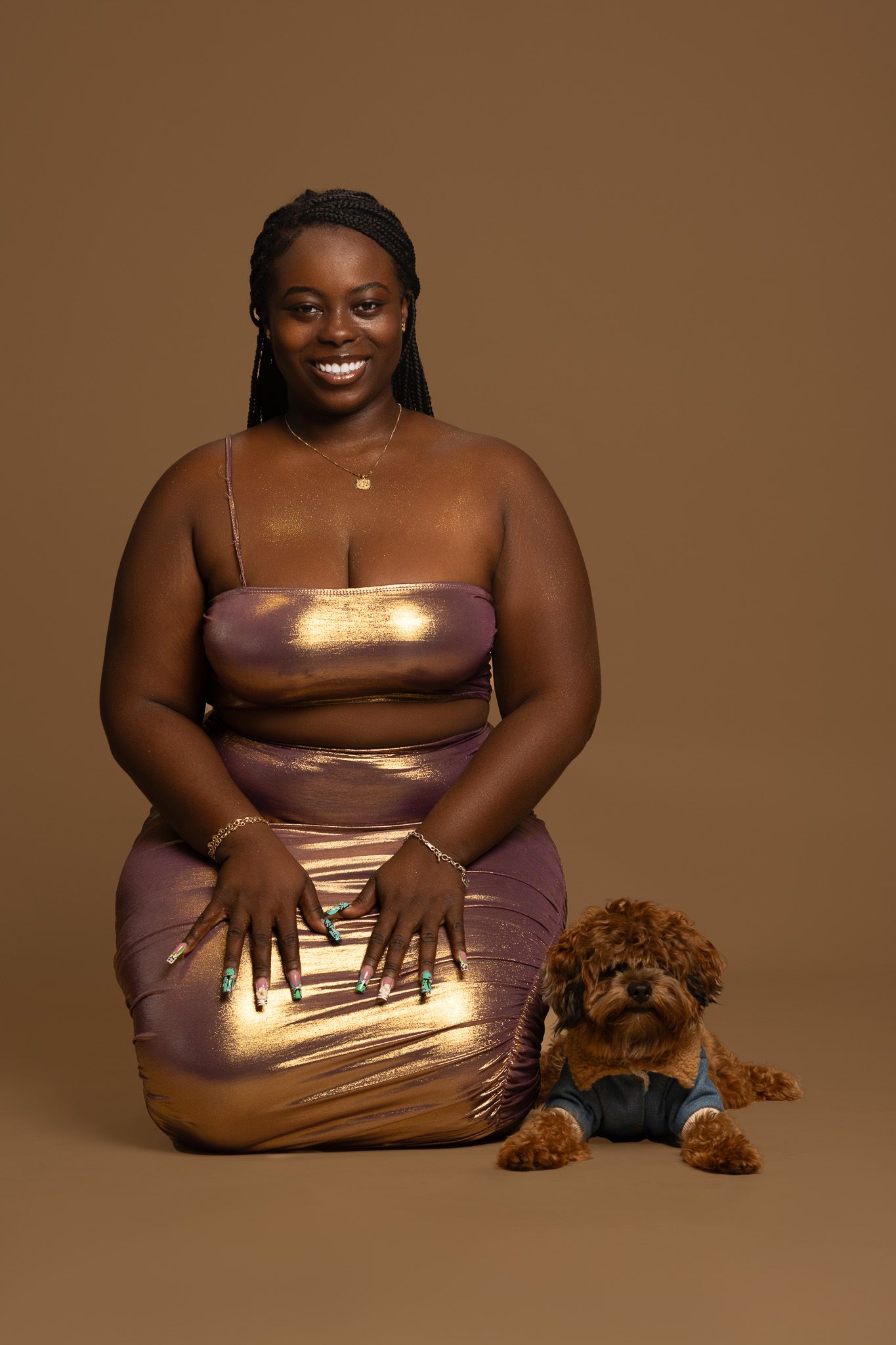 Studio portrait in metallic dress with warm brown background and plush toy.