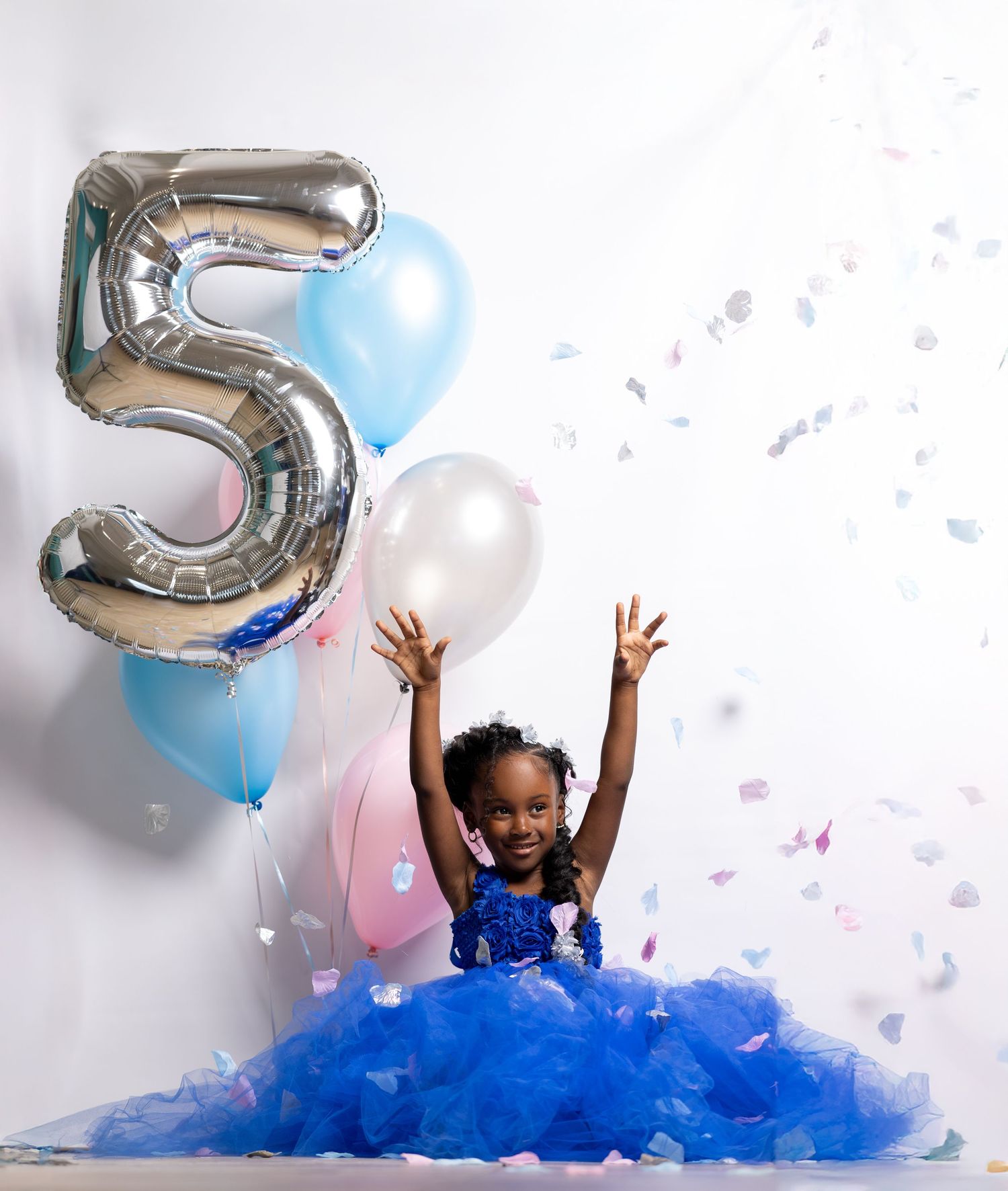 Celebration scene with blue tulle dress, silver number balloons, and floating confetti.