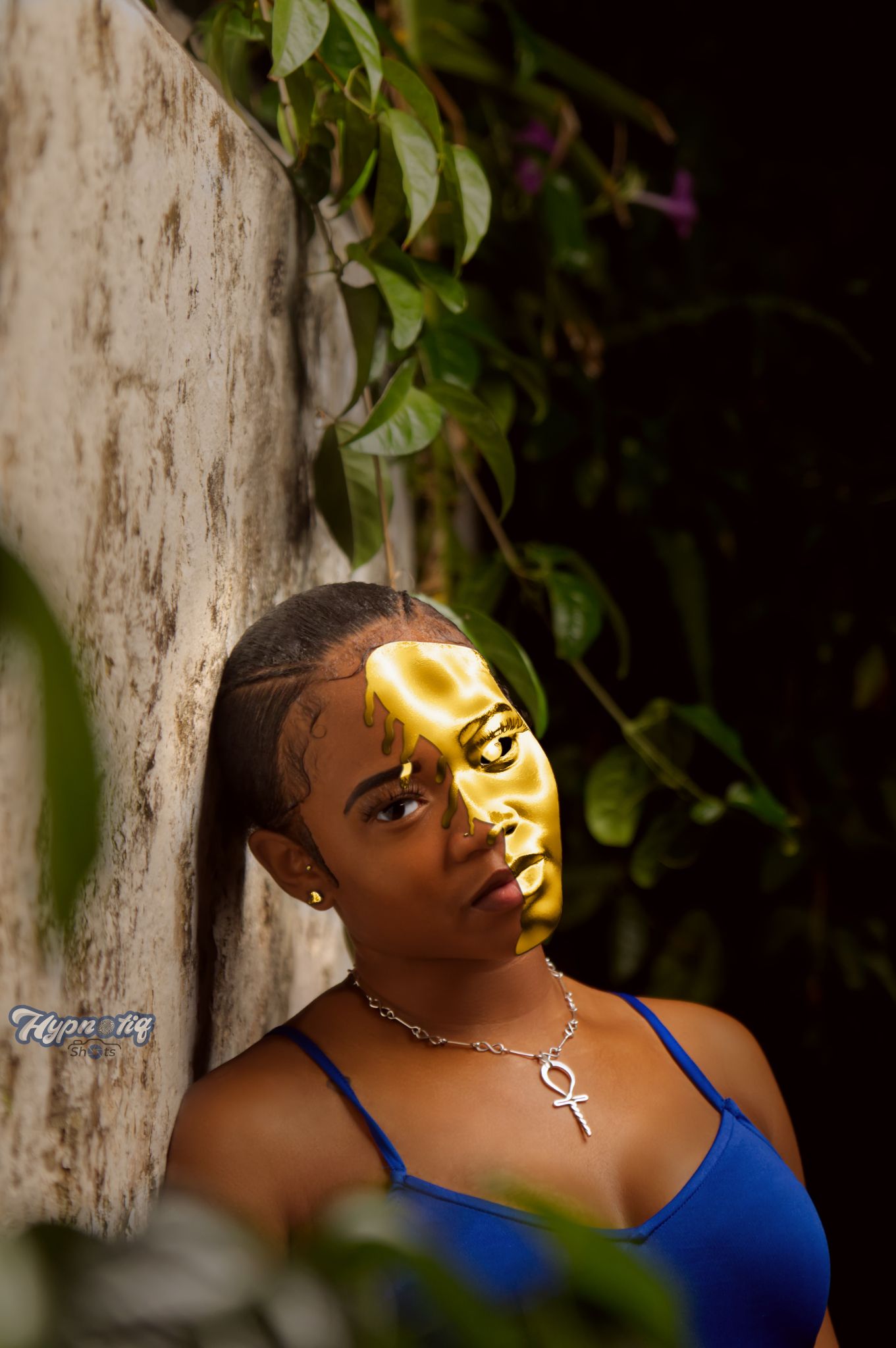 Artistic outdoor portrait with dramatic natural sunlight and foliage backdrop.
