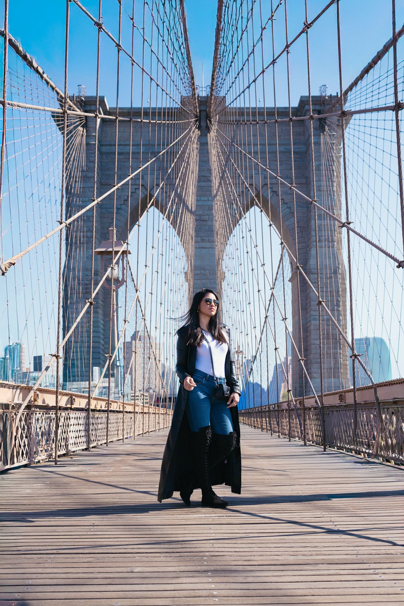 Portrait on the Brooklyn Bridge with city skyline in background.