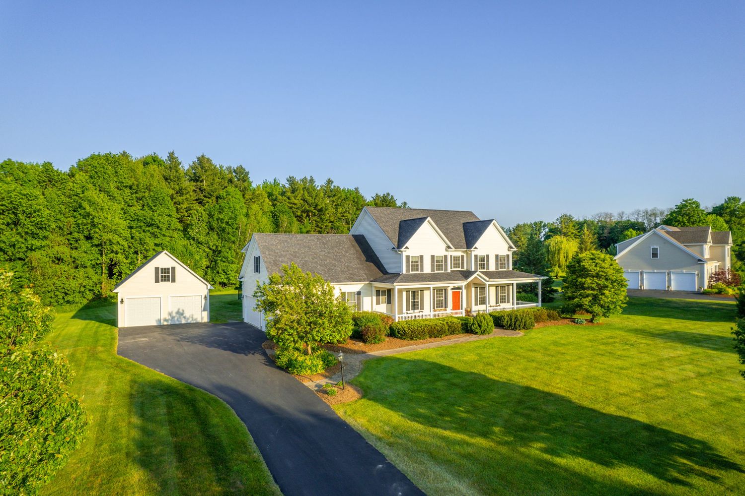 Panoramic view of suburban homes with well-maintained lawns along a quiet residential street.