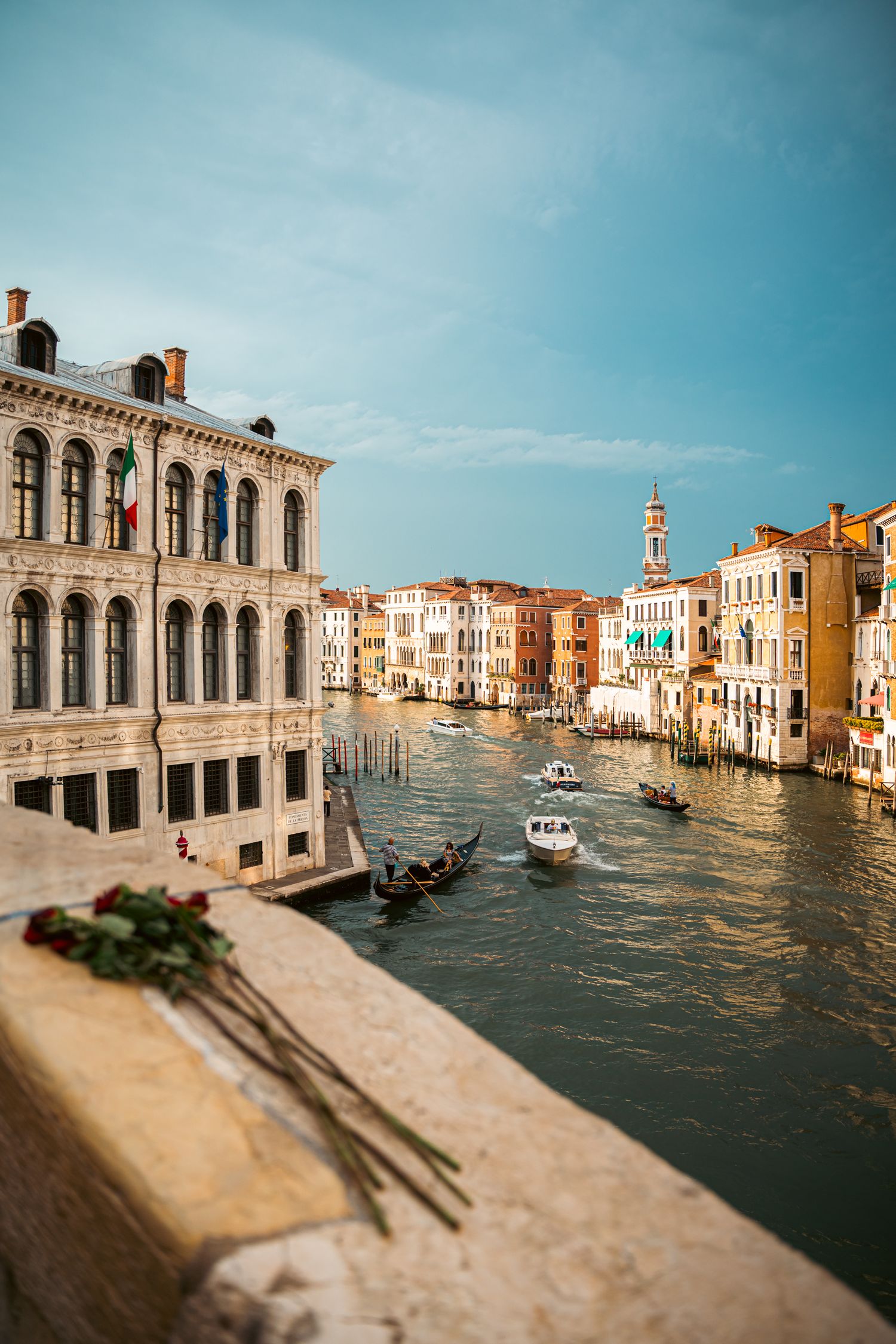 A panoramic view of Venice's Grand Canal with historic buildings and gondolas reflecting in the turquoise waters.