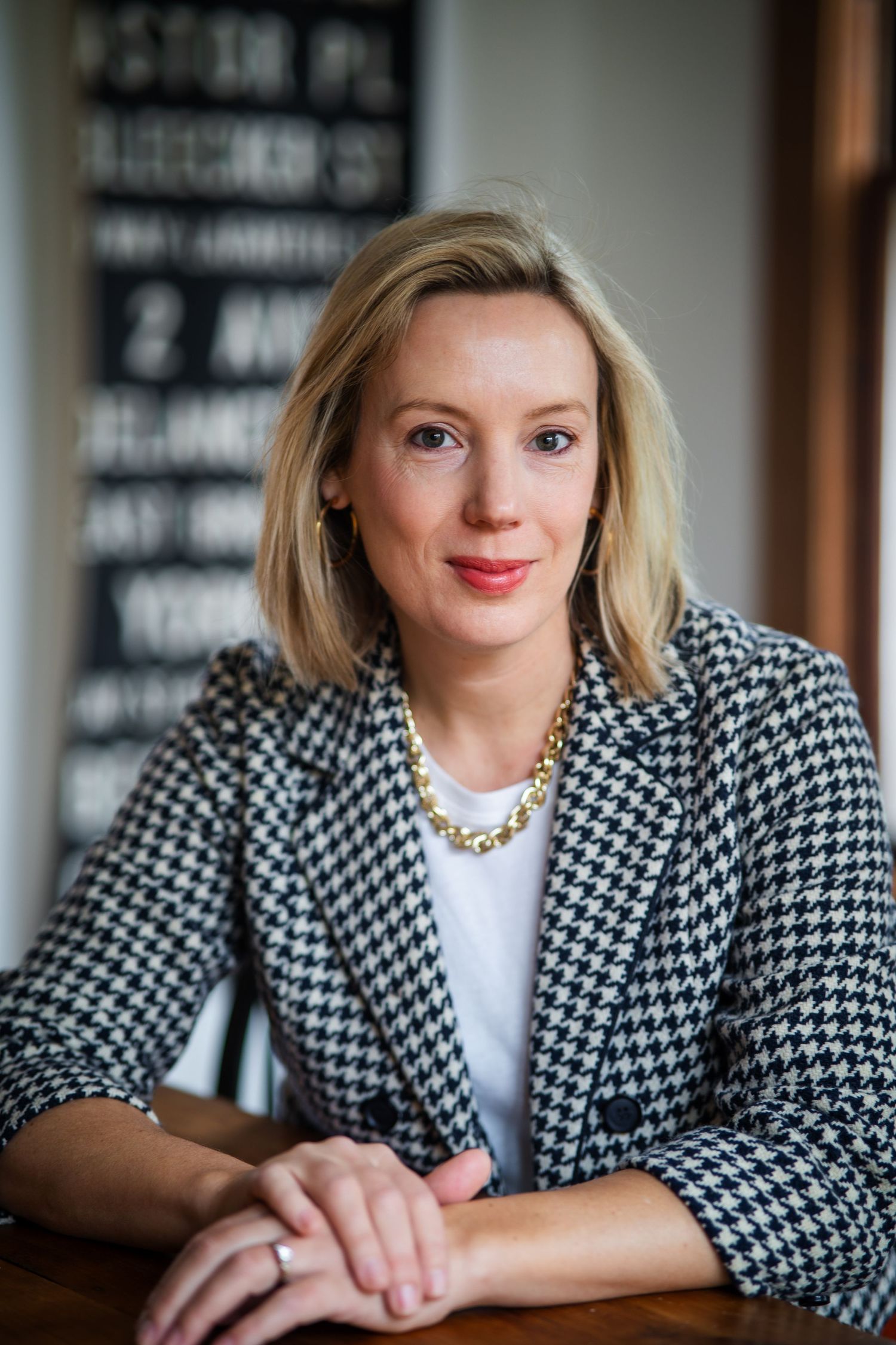 Professional portrait series showing a person in a black and white houndstooth blazer and white top against a dark background.
