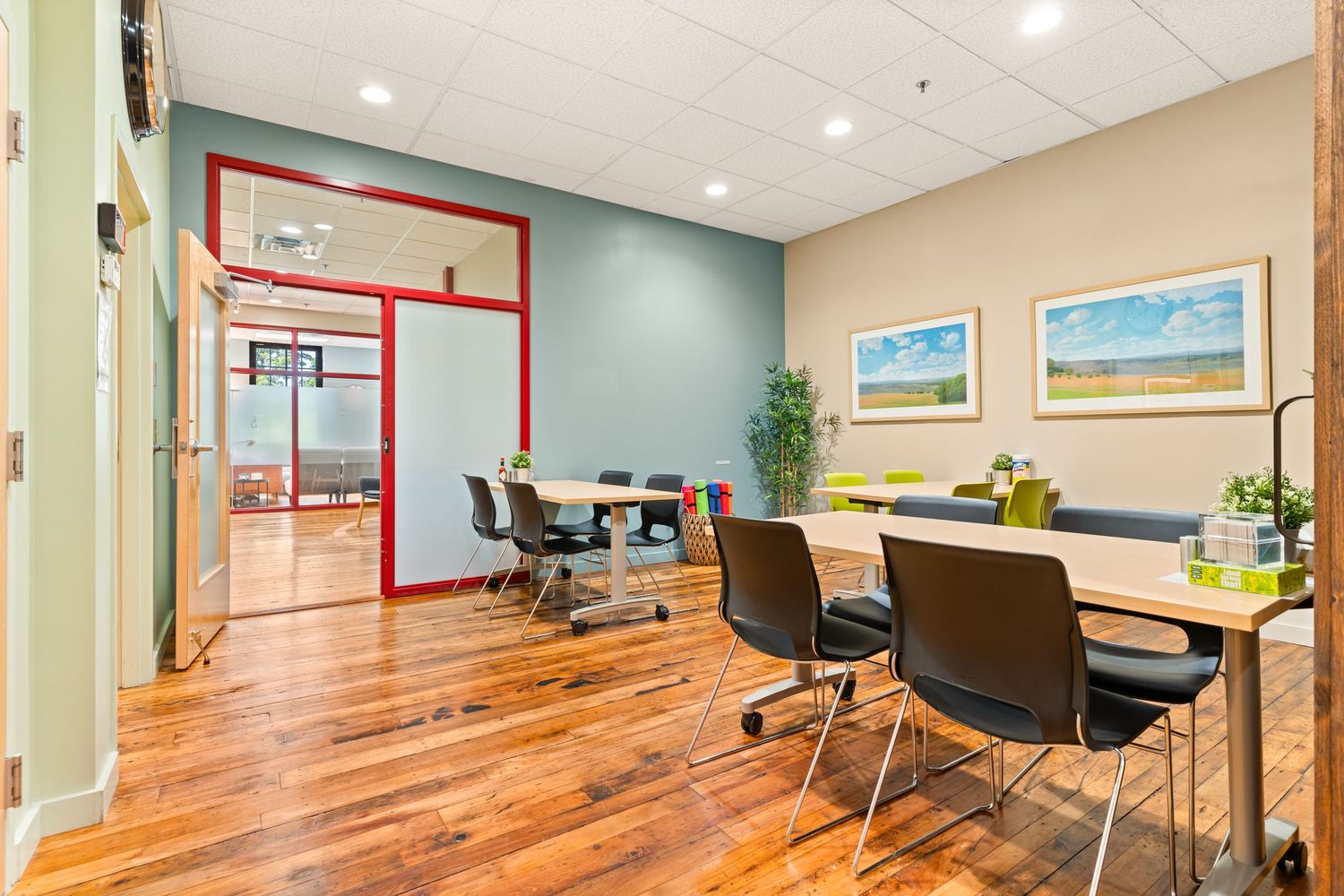 Clean modern office space with wooden floors and comfortable seating arrangements.