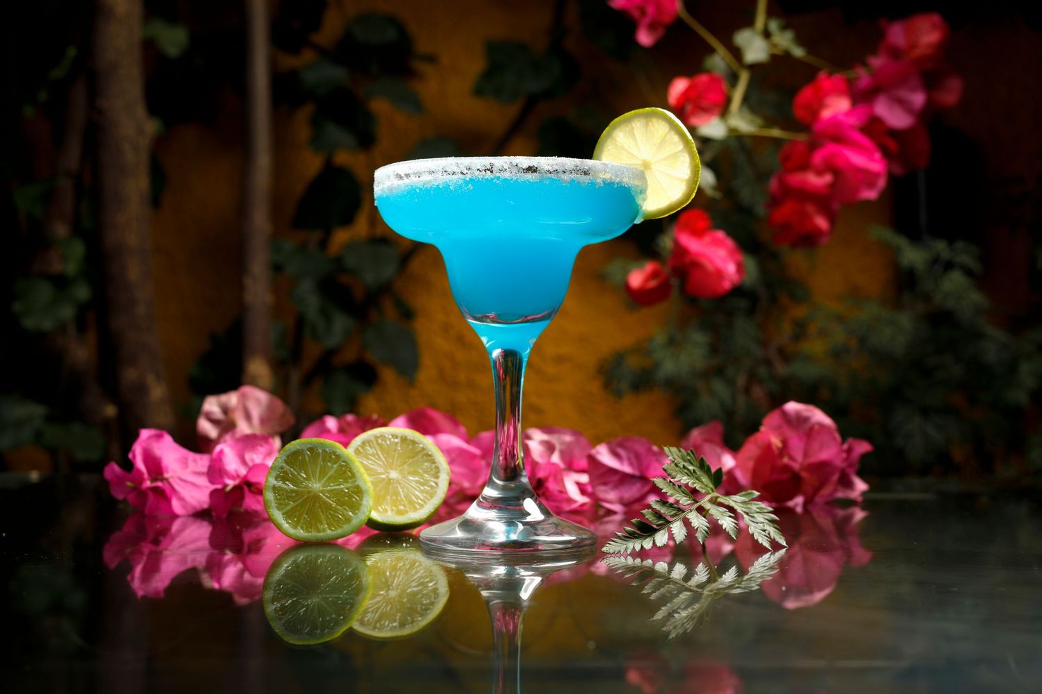 Cóctel azul de tequila con flores y cítricos, fotografía creativa de bebida para carta de restaurante o bar.
