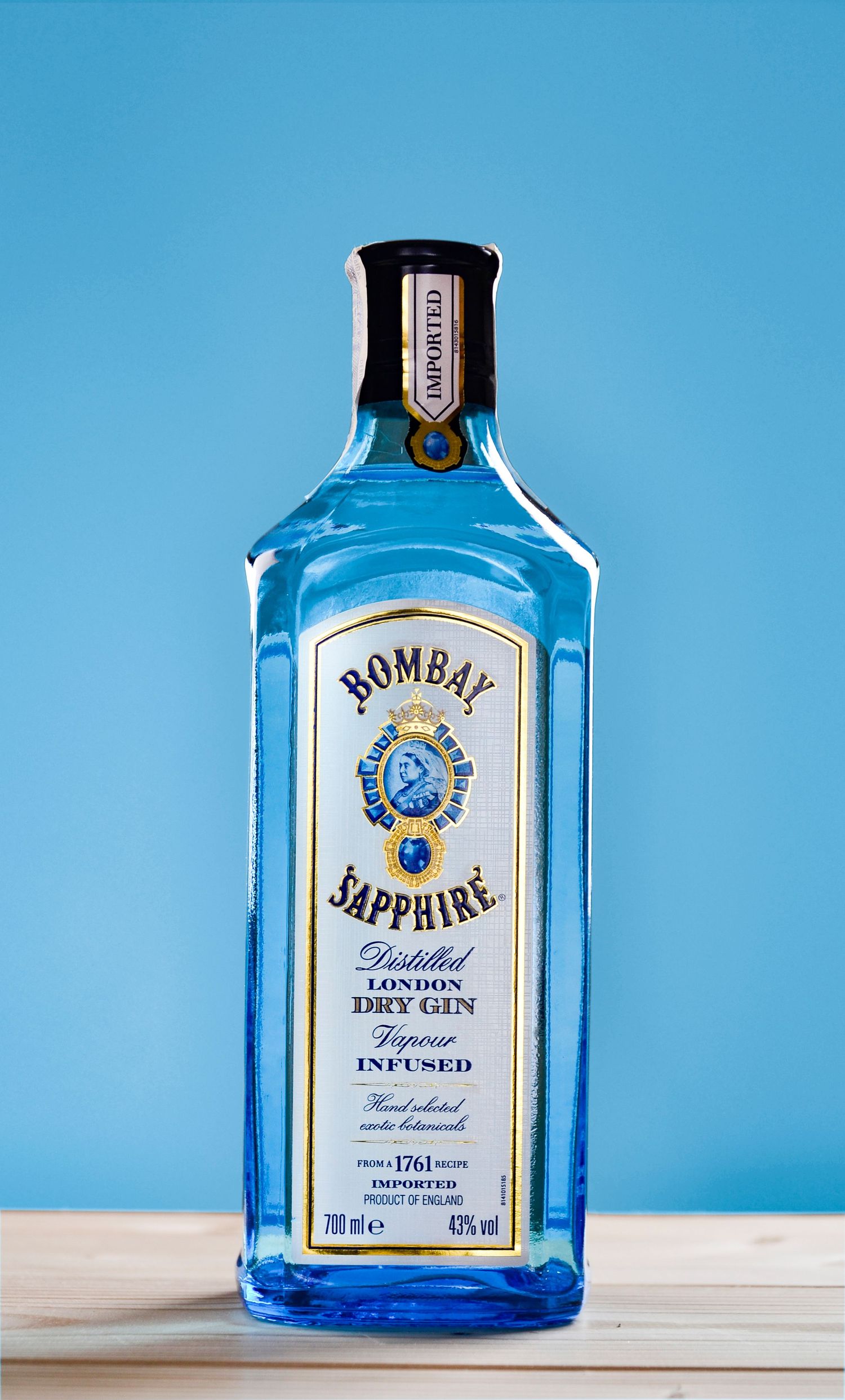 Fotografía de botella azul sobre fondo celeste. Fotografía de producto creativa en Oviedo para marcas que buscan destacar online.