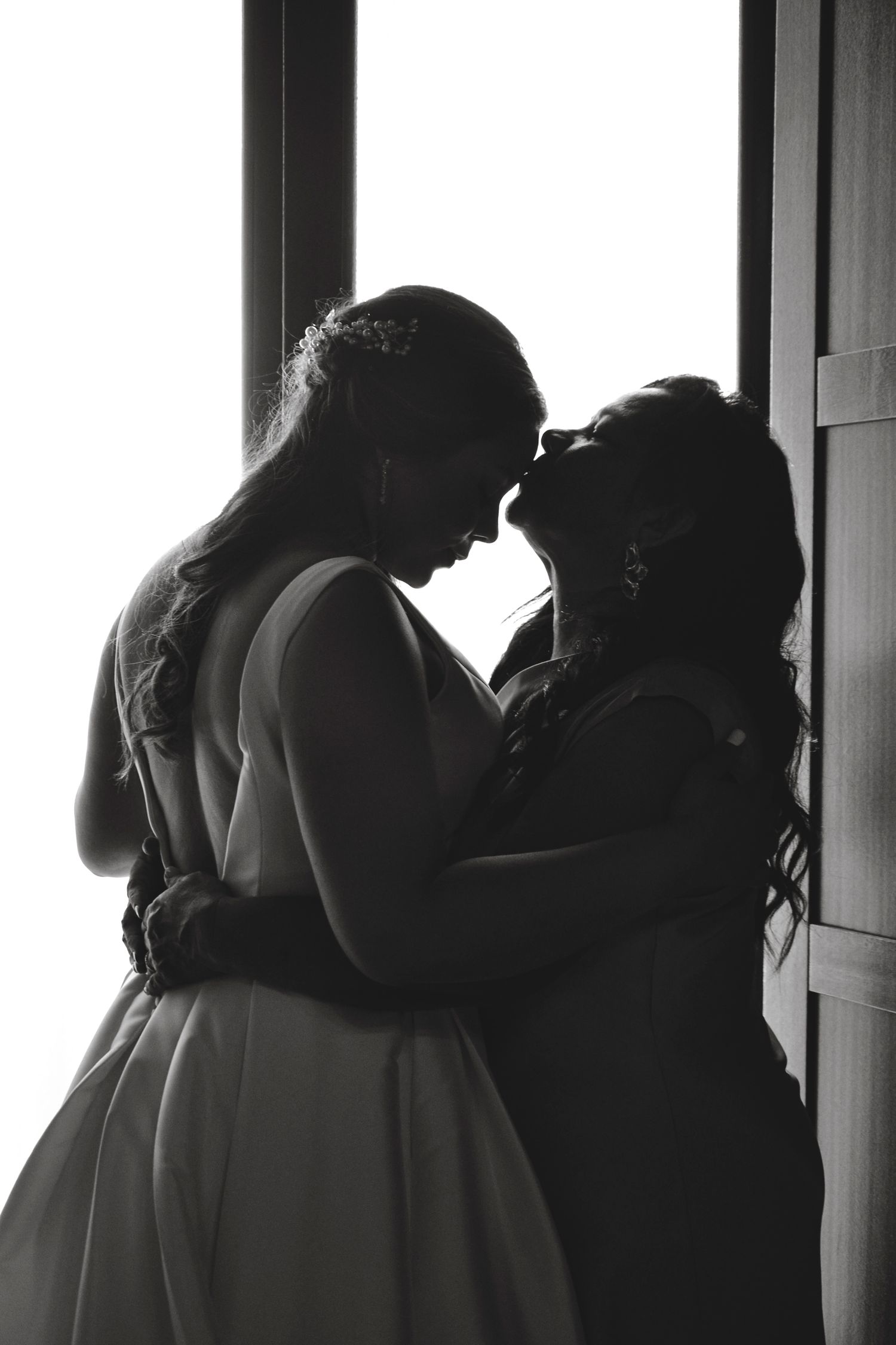 Madre e hija antes de bajar a la ceremonia.
Fotografía en blanco y negro artística a contraluz