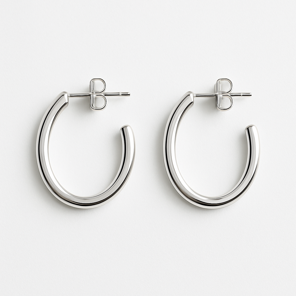 Pendientes de aro plateados sobre fondo blanco. Fotografía de producto para tienda online de accesorios y joyas.