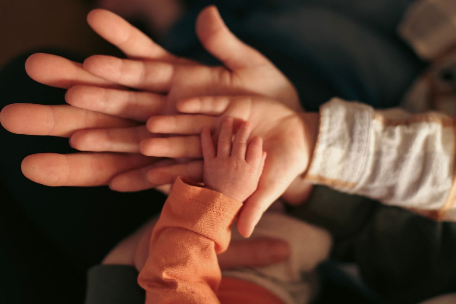 A family of four stacking their hands on top of each other's.