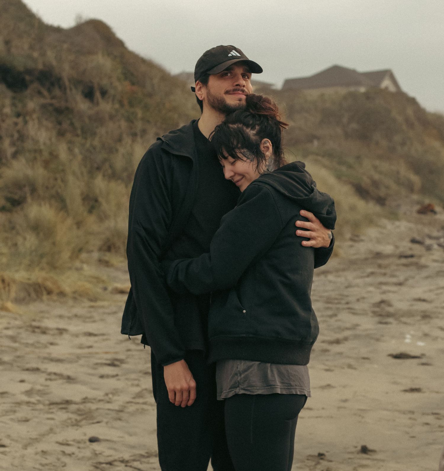 A couple embraces on a moody, dreamy, Oregon coastal shore for an engagement photoshoot