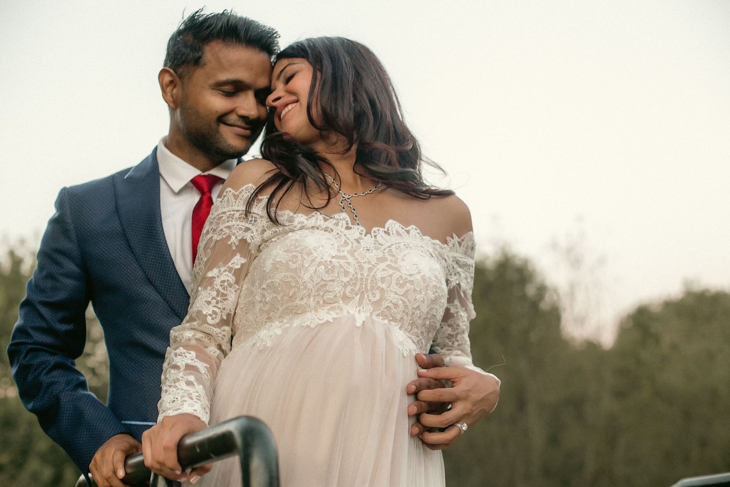 A couple touches foreheads together and smiles as they pose for baby shower photos at a venue in Southeast Portland, Oregon.