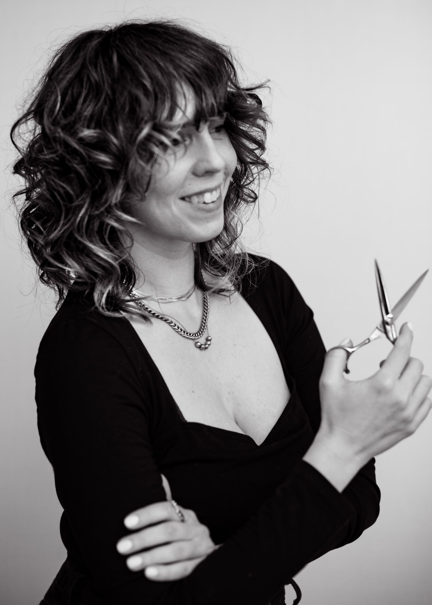 Woman holding hair cutting scissors for hair styling branding shoot black and white
