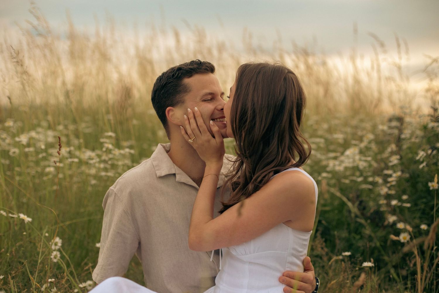 An engagement photo of a man and woman in a field of flowers